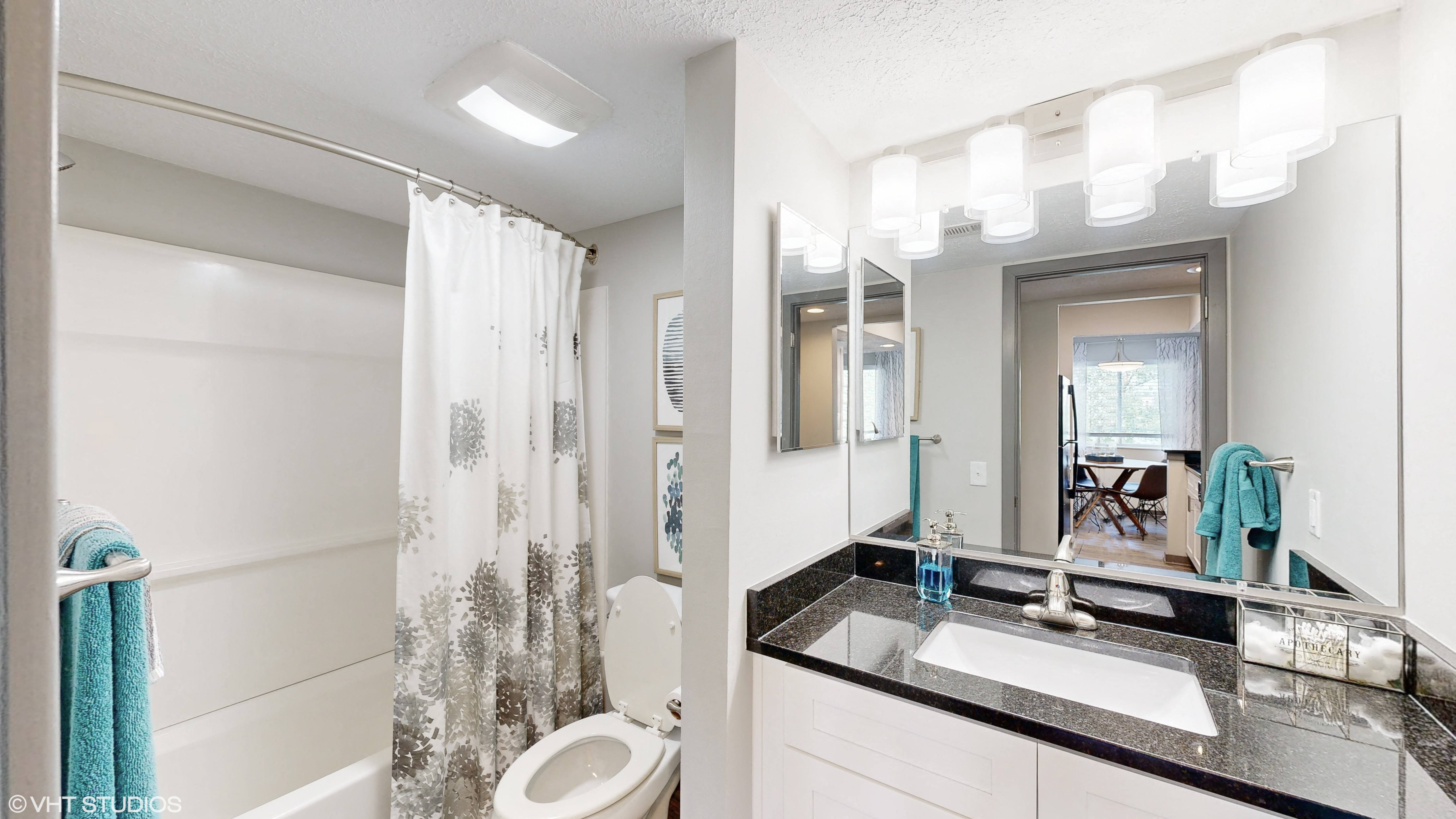apartment bathroom with tub and vanity